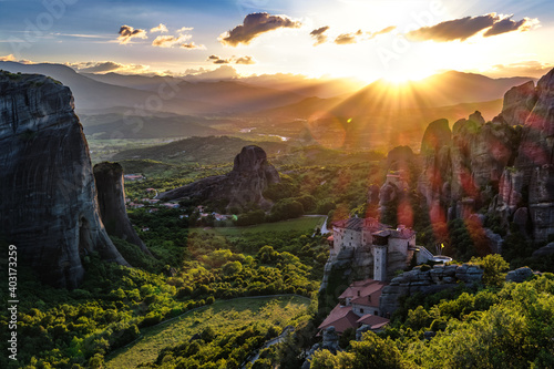 Iconic view of Meteora valley at sunset, mountains, rocks, Moni Agias Varvaras Roussanou nunnery, natural lens flare, Greece, UNESCO World Heritage photo