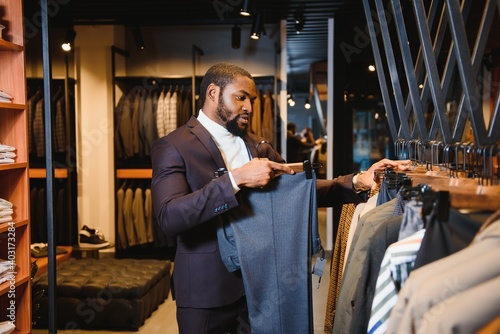 African American man, clothing store, chooses clothes