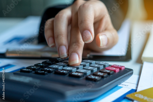 Businessmen use a calculator to calculate income and expenses in order to manage budgets to pay off credit card debt.