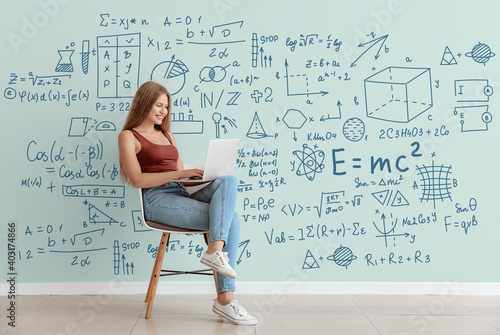 Young woman with laptop studying exact mathematical sciences. Concept of online education photo