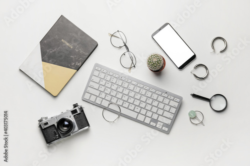 Composition with computer keyboard, camera and mobile phone on white background