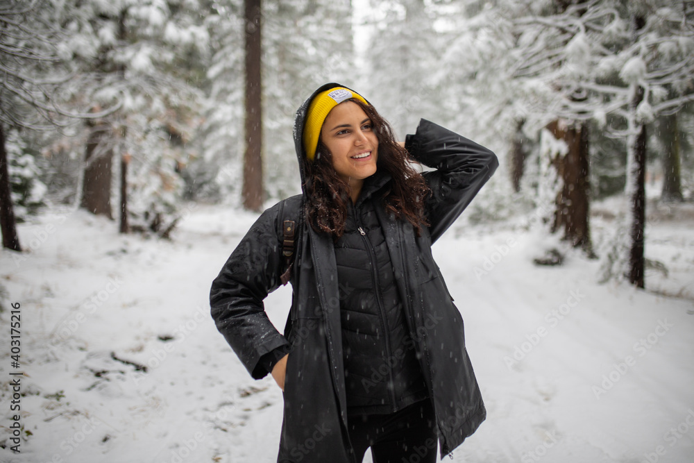 Happy woman standing in the middle of a snowy forest