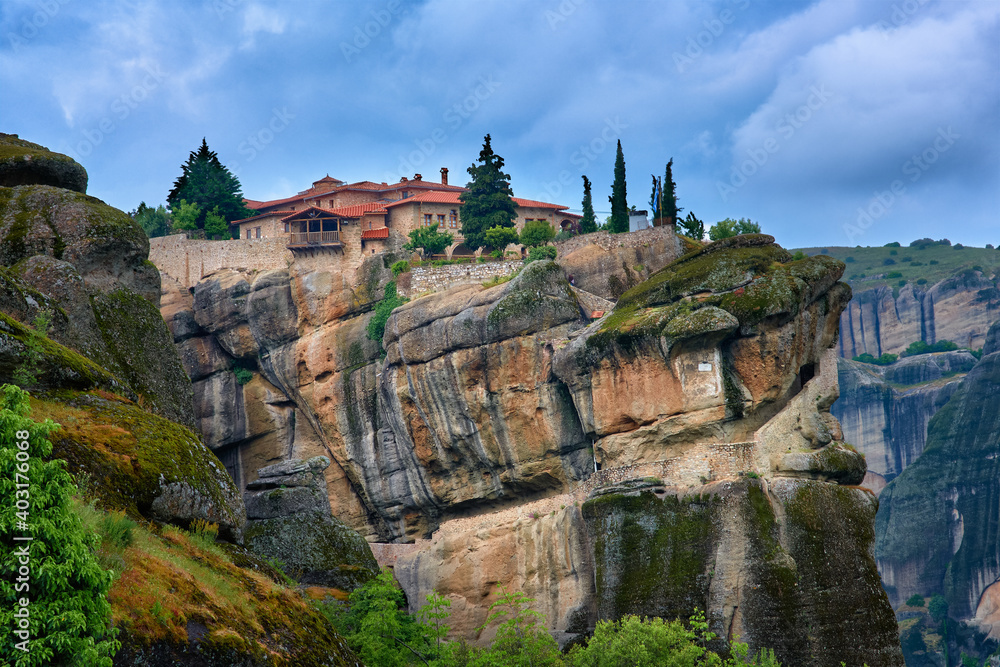 Close view of clifftop Eastern Orthodox monastery of Holy Trinity or Agia Triada in famous Meteora valley, Greece, UNESCO World Heritage, cloudy sky