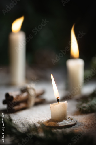 Winter magic composition. burning candles, spruce branches, cinnamon. New year, Christmas Greeting card Winter mood
