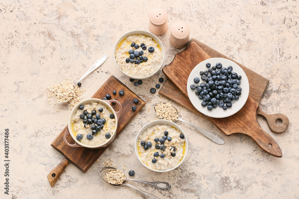 Bowls with tasty oatmeal and blueberry on table Bowls with tasty oatmeal and blueberry on table