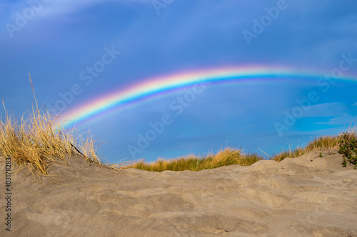 Rainbow over the sand dunes of the Mediterranean coastline photo