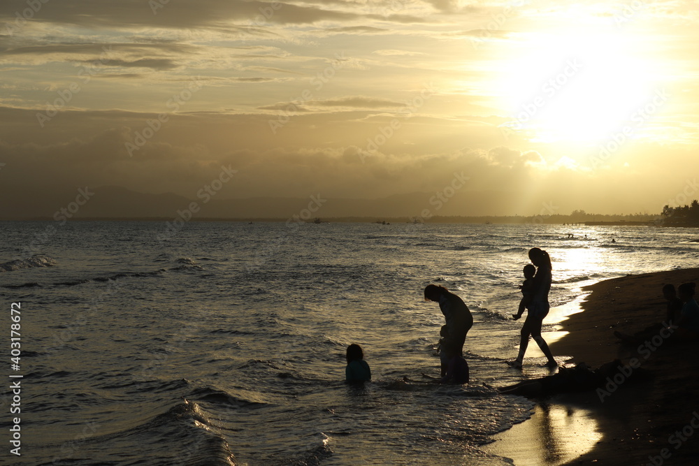 silhouette of a family enjoying the beach in sunset background silhouette of a family enjoying the beach in sunset background