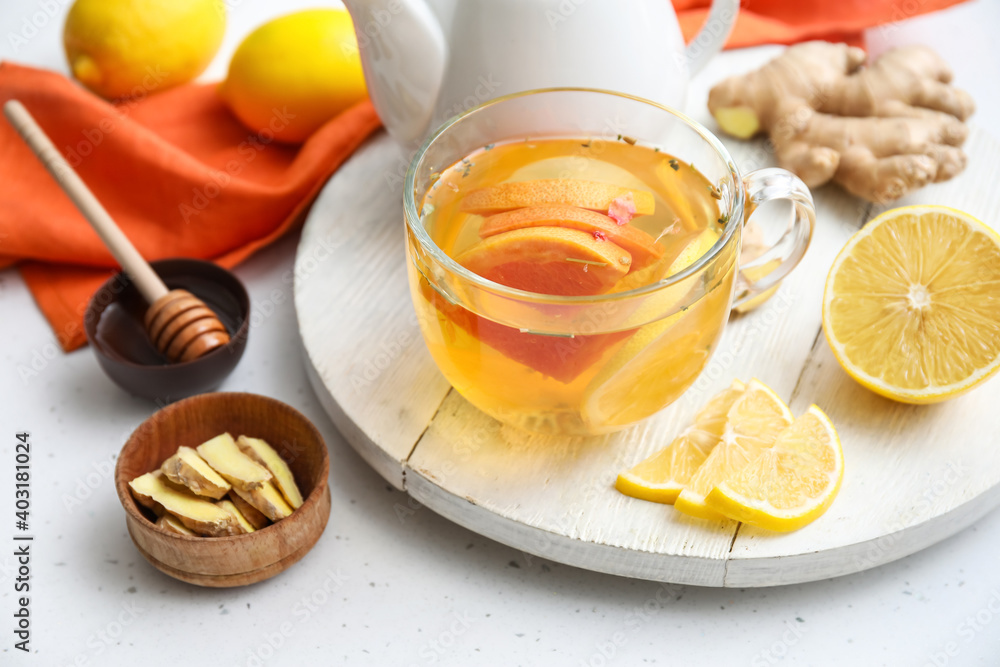 Board with cup of aromatic tea with lemon, ginger and honey on table Board with cup of aromatic tea with lemon, ginger and honey on table