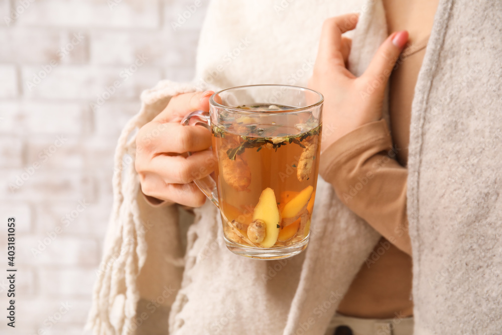 Woman holding cup of hot ginger tea, closeup - obrazy, fototapety, plakaty 