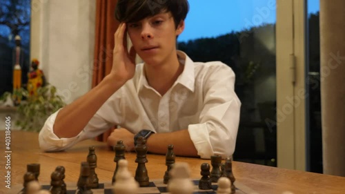 Ragazzo concentrato che sposta una pedina su una scacchiera durante una partita a di scacchi
Primo piano sulla scacchiera con movimento laterale photo