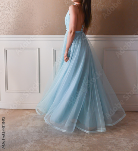 Model dressed with a long blue dress is having a photo shooting