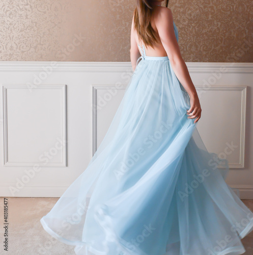 Model dressed with a long blue dress is having a photo shooting
