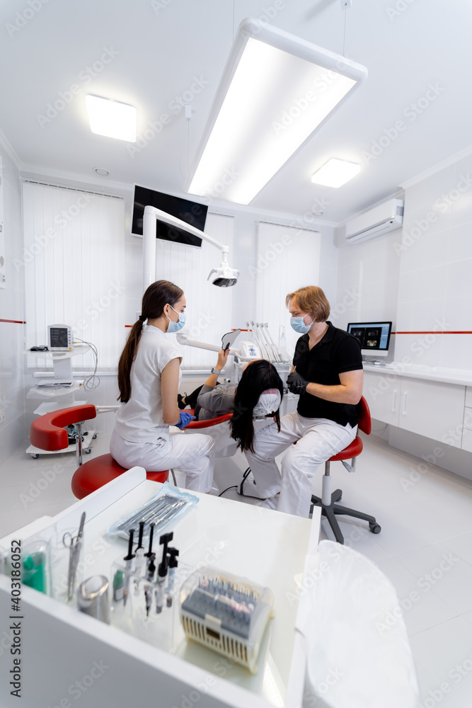 Female assistant and male dentist are working in modern stomatology clinic. Stomatological instrument in the dentist clinic. Female assistant and male dentist are working in modern stomatology clinic. Stomatological instrument in the dentist clinic.