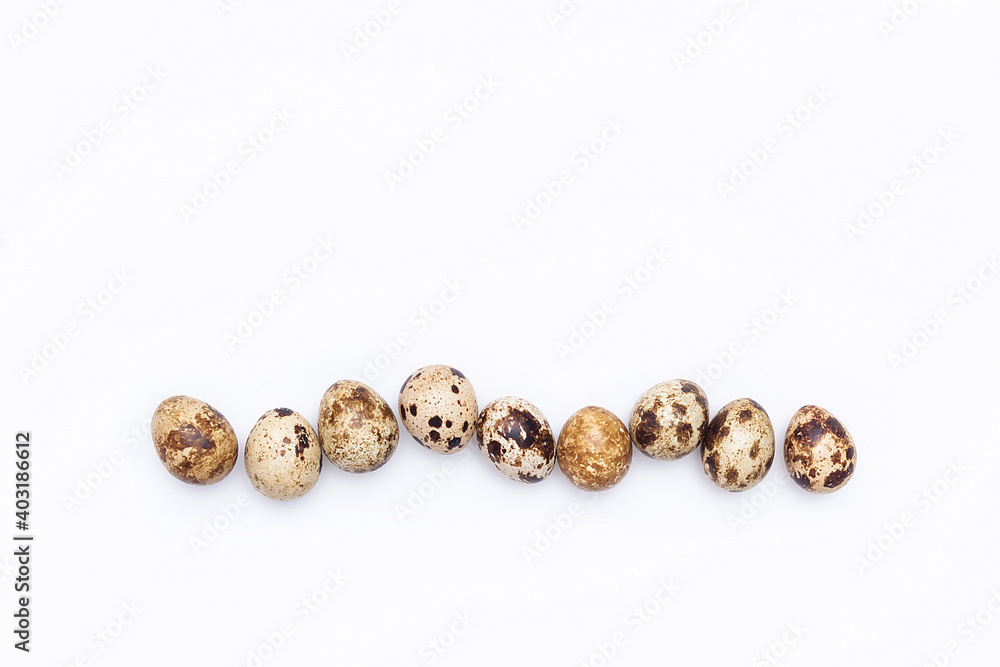 A row of quail eggs on a white background. Top view Flat lay Copy space A row of quail eggs on a white background. Top view Flat lay Copy space