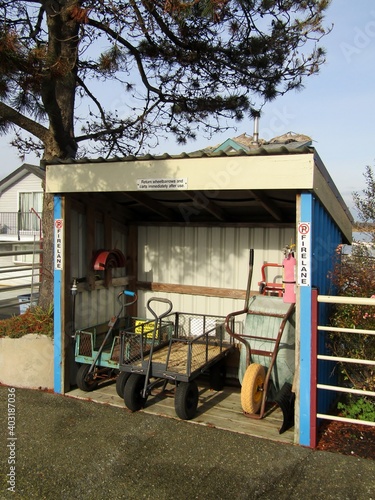Shed with wheelbarrows, utility carts, hose and fire extinguisher