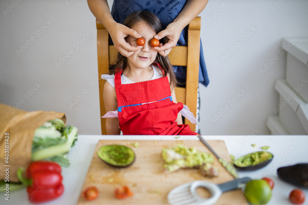 Happy mother and daughter playing with their food Happy mother and daughter playing with their food