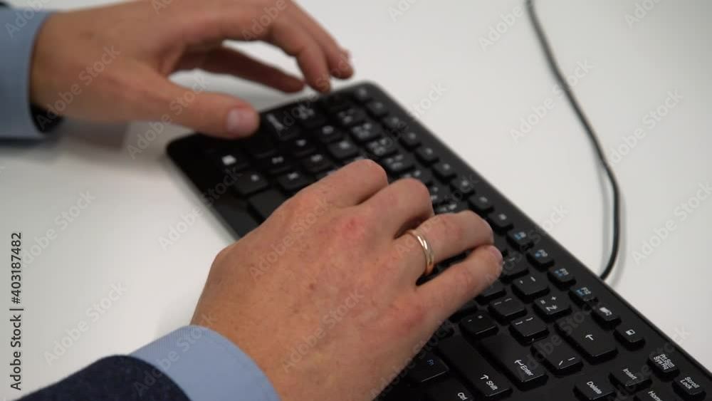 Closeup of man hands typing keyboard at the office. Business man in a suit working online with a desktop computer. Closeup of man hands typing keyboard at the office. Business man in a suit working online with a desktop computer.