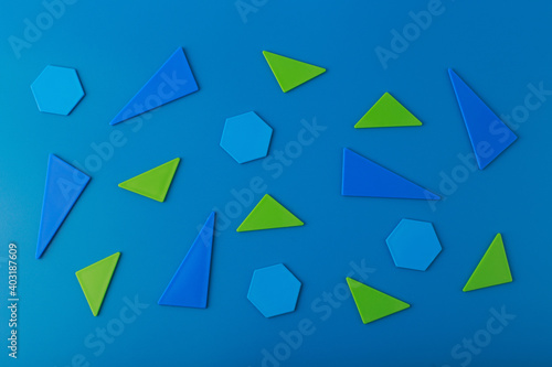 Abstract background with blue triangles, hexagons and orange squares on blue background. Flat lay in minimalistic duotone colors and futuristic style