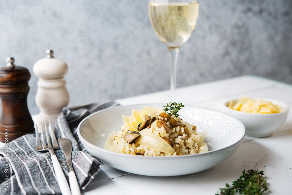 Risotto with porcini mushrooms and parmesan on a light background