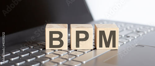 BPM Business Process Management written on a wooden cube on laptop photo