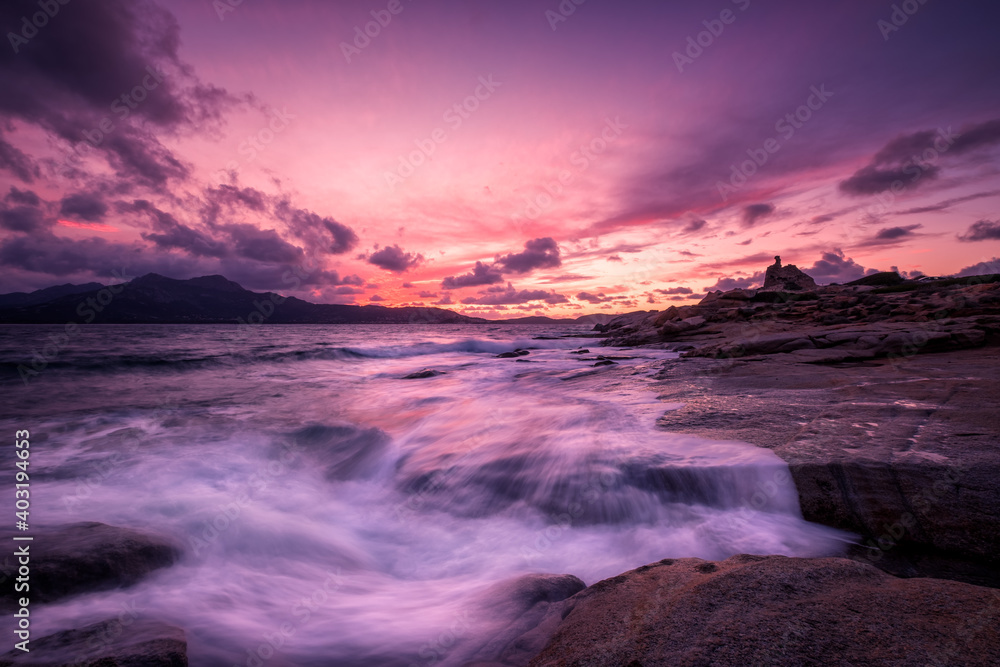 Sunset over tower and rocky coastline of Corsica