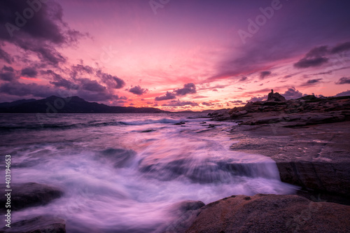 Sunset over tower and rocky coastline of Corsica