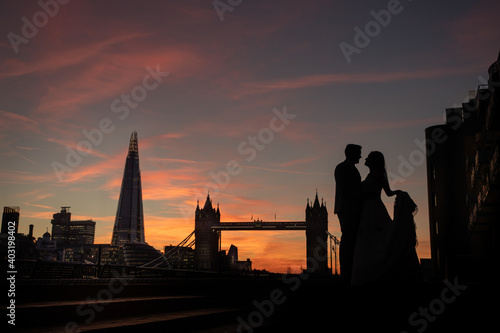Photography London Wedding photograph at Tower Bridge London at Sunset with landmarks silhouetted in the background