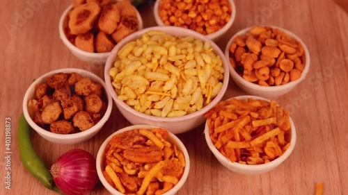 indian namkeen on wooden table,Indian Namkeen or snacks in white bowl on wooden background, close up of indian Namkeen snacks beautiful footage,Sev murmura,chanadal,shing bhujia,mix chavana