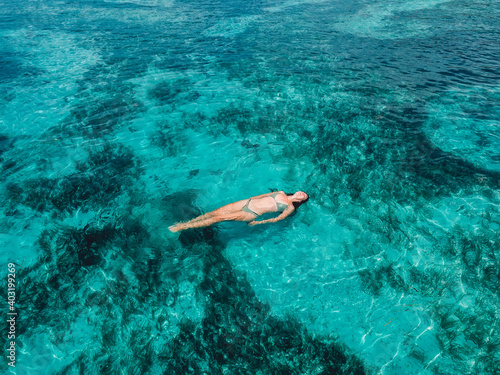 Young woman swimming in turquoise sea. Aerial view