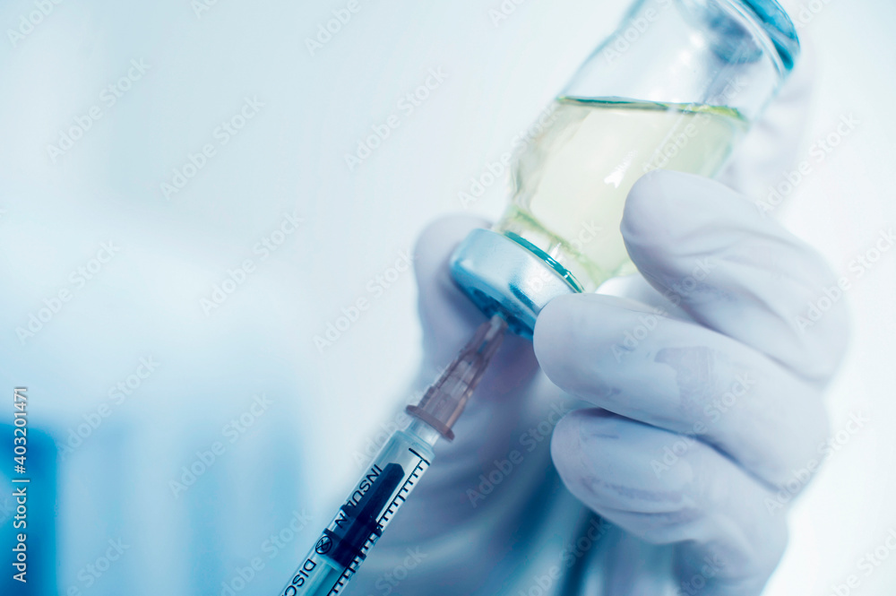 a nurse draws a vaccine into a syringe. close-up. vaccination concept covid-19 a nurse draws a vaccine into a syringe. close-up. vaccination concept covid-19