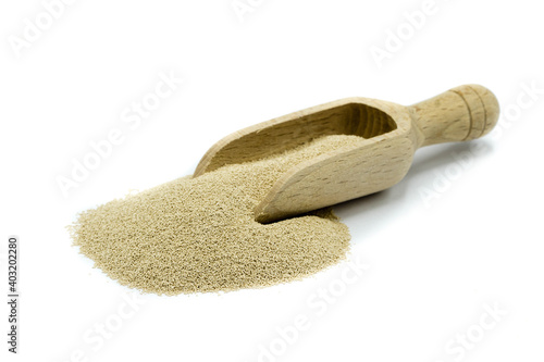 Dry baker's yeast isolated on white background with wooden scoop