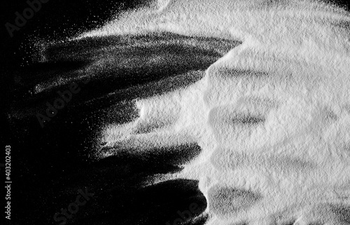 Baking soda pile, sodium bicarbonate isolated on black background, top view