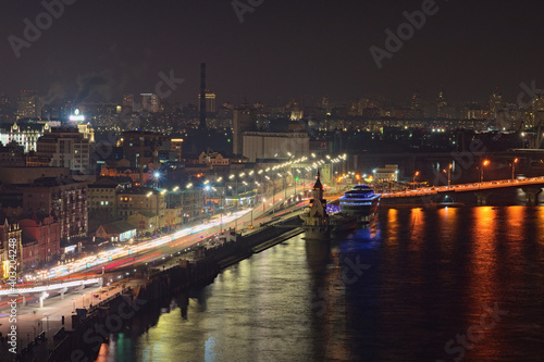 Kyiv, Ukraine-January 02,2021:Scenic aerial view of Kyiv during night. Night lights landscape of ancient Podil and river port of Kyiv. Beautiful illumination of the city. Aerial view from the hill