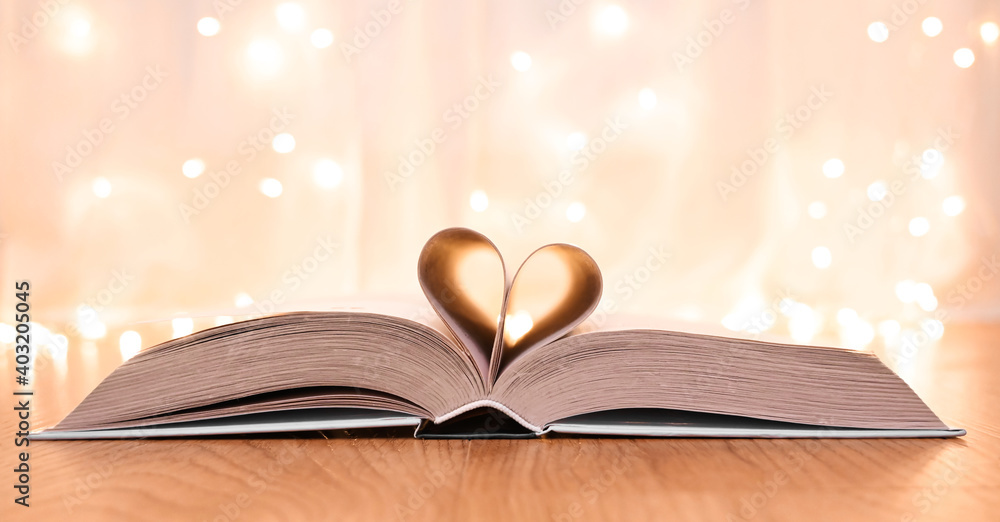 Heart-shaped pages of book on bokeh background. St. Valentine's concept.Valentine's card.