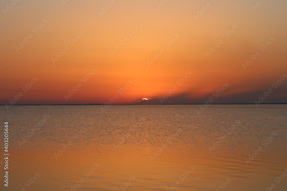 Fototapeta premium landscape of the sunset on the sea behind the clouds