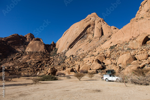 camping with a pickup camper with car roof tent in front of  mountains