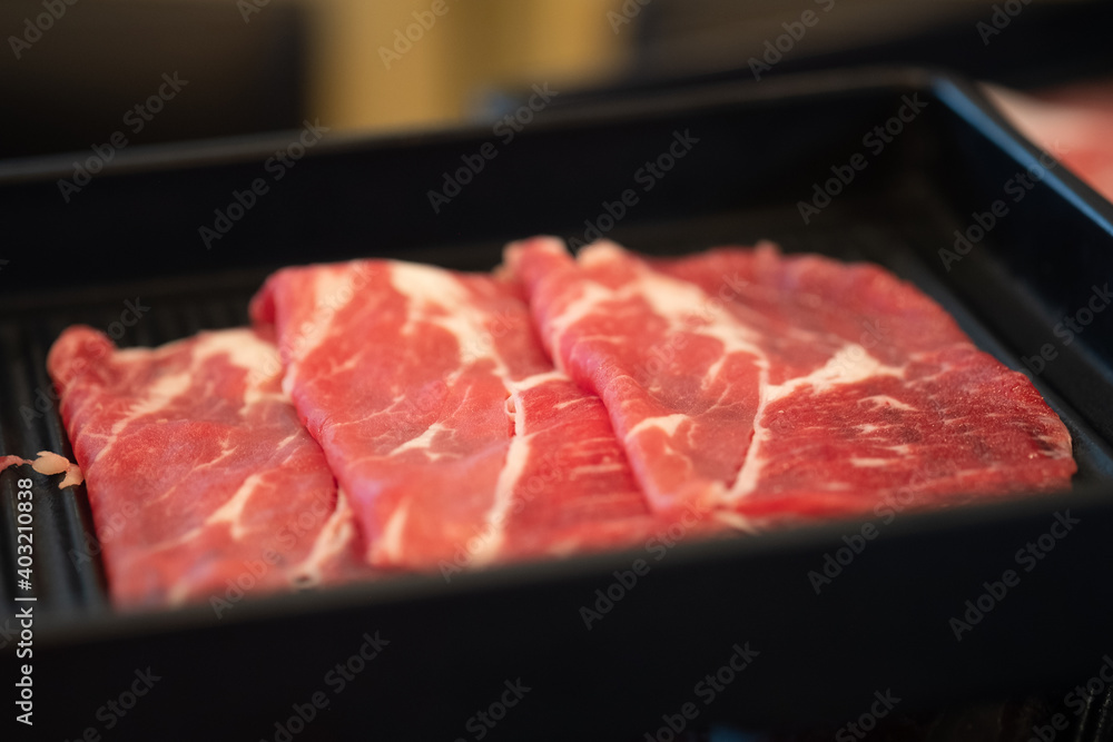 Raw sliced Wagyu beef for shabu shabu on black tray. Raw sliced Wagyu beef for shabu shabu on black tray.