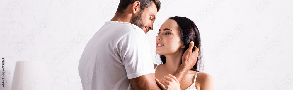 passionate young man in t-shirt looking at brunette woman indoors, banner passionate young man in t-shirt looking at brunette woman indoors, banner