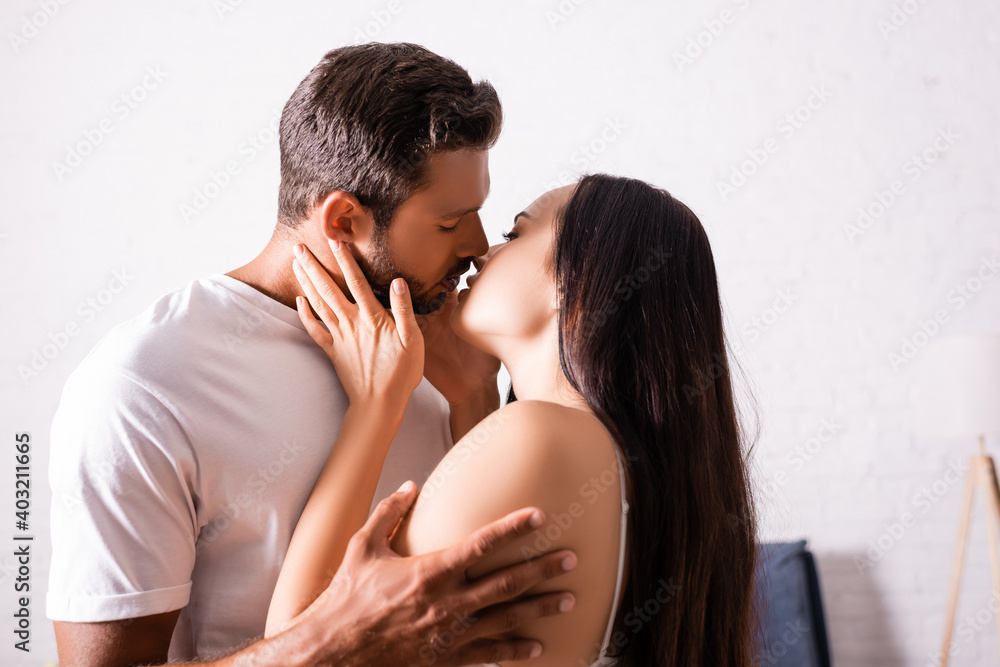 sensual young couple kissing in bedroom sensual young couple kissing in bedroom