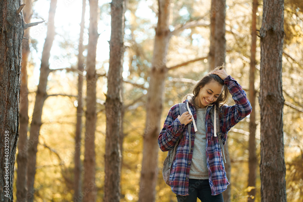 cheerfulness casual woman at fall forest with sun rays on background, feeling good hiking in woods. concept activity and adventure outdoors cheerfulness casual woman at fall forest with sun rays on background, feeling good hiking in woods. concept activity and adventure outdoors