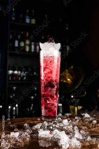 Close-up soft drink with cherry and ice in a tall glass