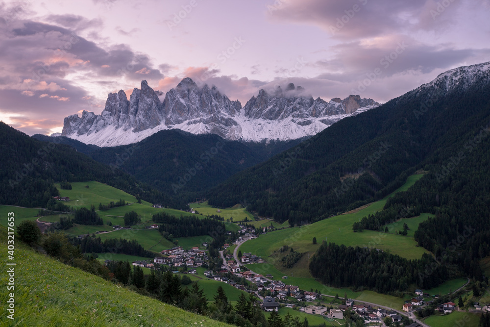 Sunrise over the small Italian mountain town of St. Magdalena in Val di Funes