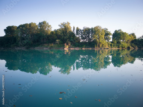 Fiume Piave al tramonto con vista panoramica sugli alberi di laguna con  acqua limpida e foglie che galleggiano photo