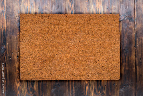 Natural coir doormat on antique wooden texture, background