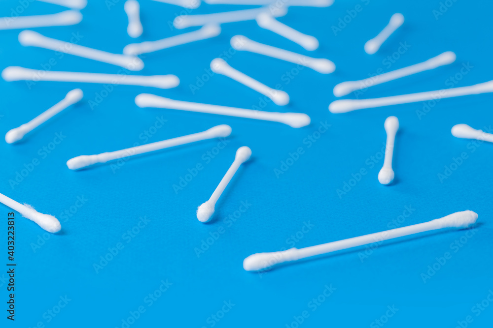 Cotton buds attached to a plastic rod on a blue background Cotton buds attached to a plastic rod on a blue background