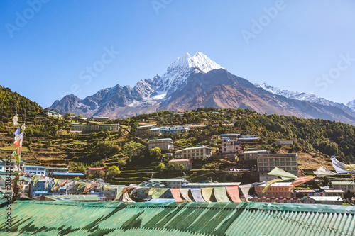 Prayer flags with Buddhist mantras in the background of Namche Bazar village. Nepal photo