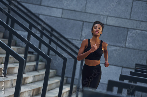 Active runner. Young african american woman in sportive clothes have workout outdoors at daytime