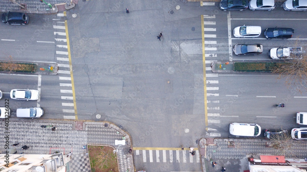 Aerial view of the city traffics at the center. Vehicles are moving on the road between buildings. Aerial view of the city traffics at the center. Vehicles are moving on the road between buildings.
