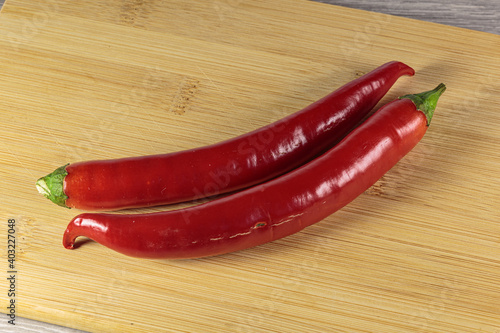 Pods of hot red pepper on the cutting board.