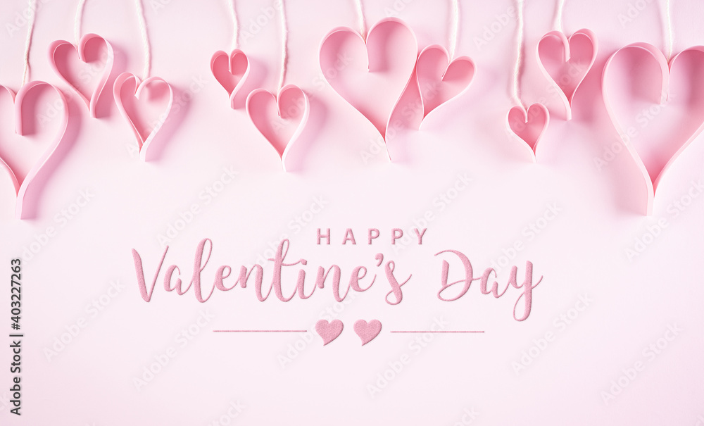 Love and Valentine's day concept. Pink paper hearts on pastel paper background. Flat lay top view with Happy Valentines Day text.